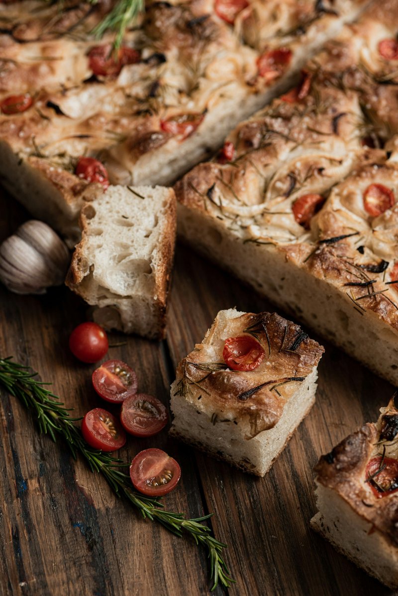 Focaccia con pomodorini e rosmarino, tagliata sul tagliere
