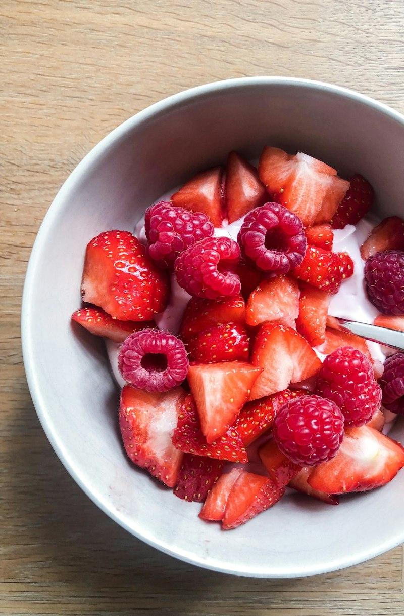 Fragole e lamponi in una ciotola bianca